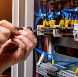 The man is repairing the switchboard voltage with automatic switches. Electrical background